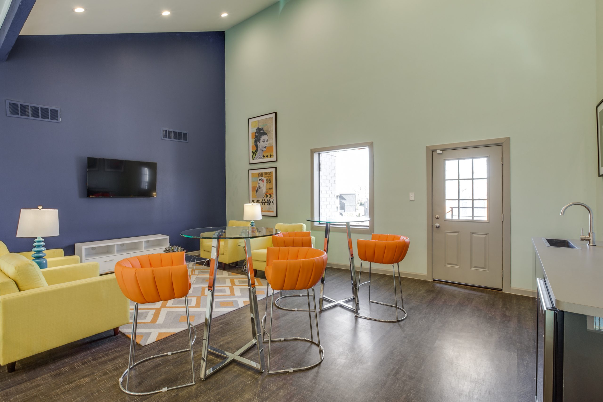 a living room with orange chairs and blue walls at The Preslee