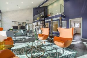 the lobby of an apartment building with orange chairs at The Preslee