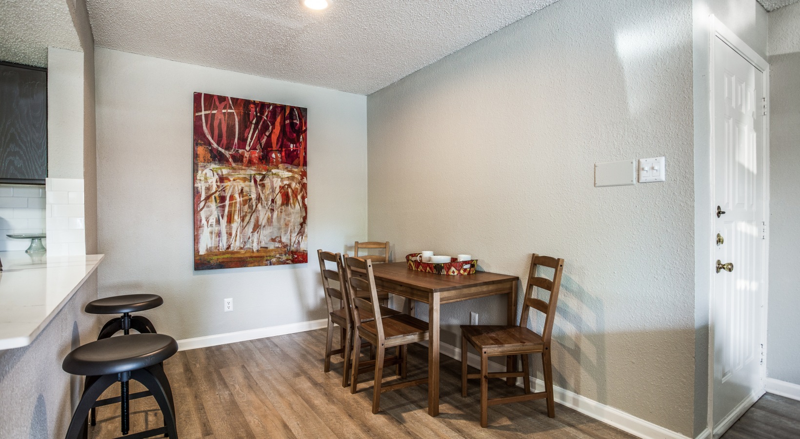 dining room with hardwood floors and a large painting at The Preslee