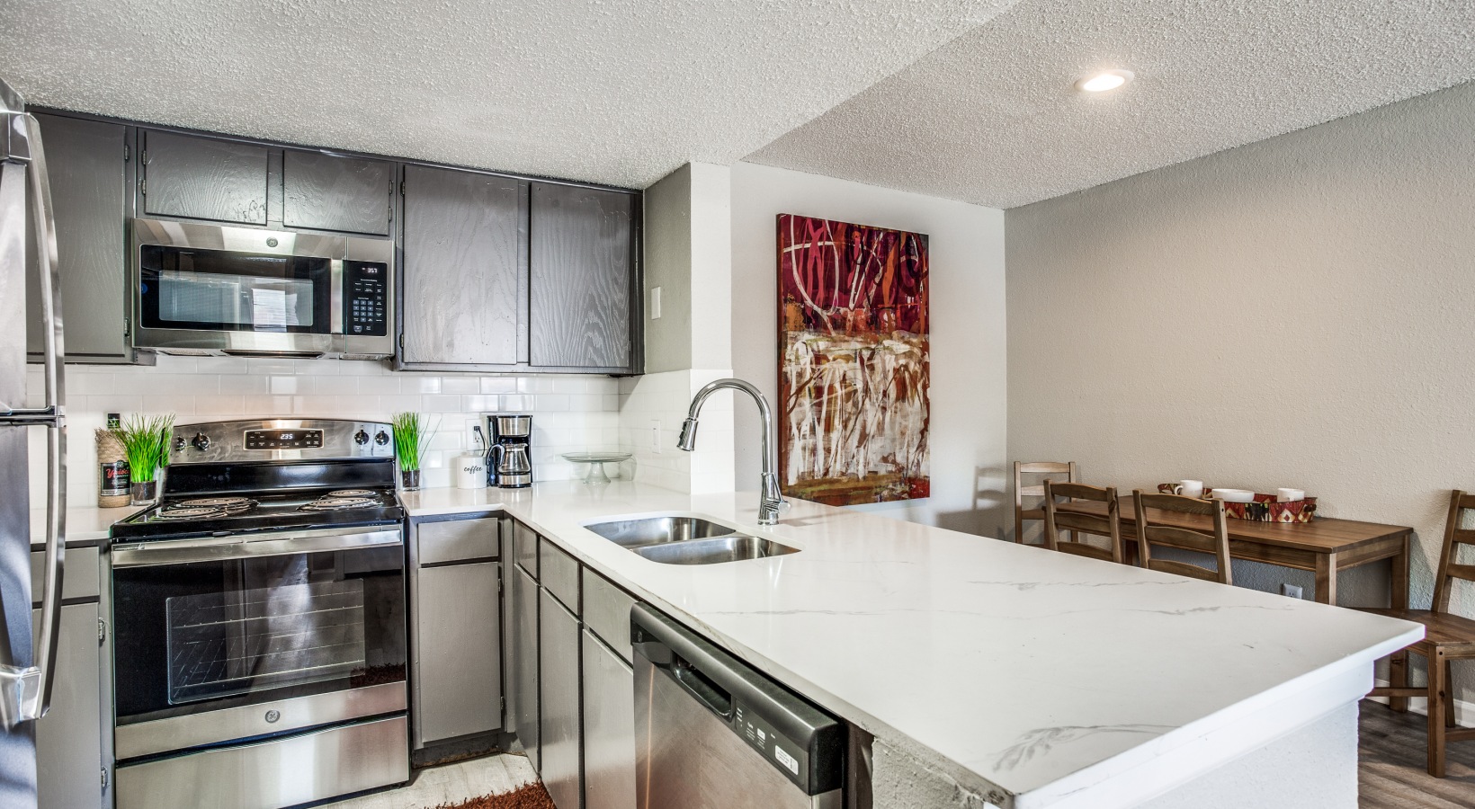 a kitchen with stainless steel appliances and a white counter top at The Preslee