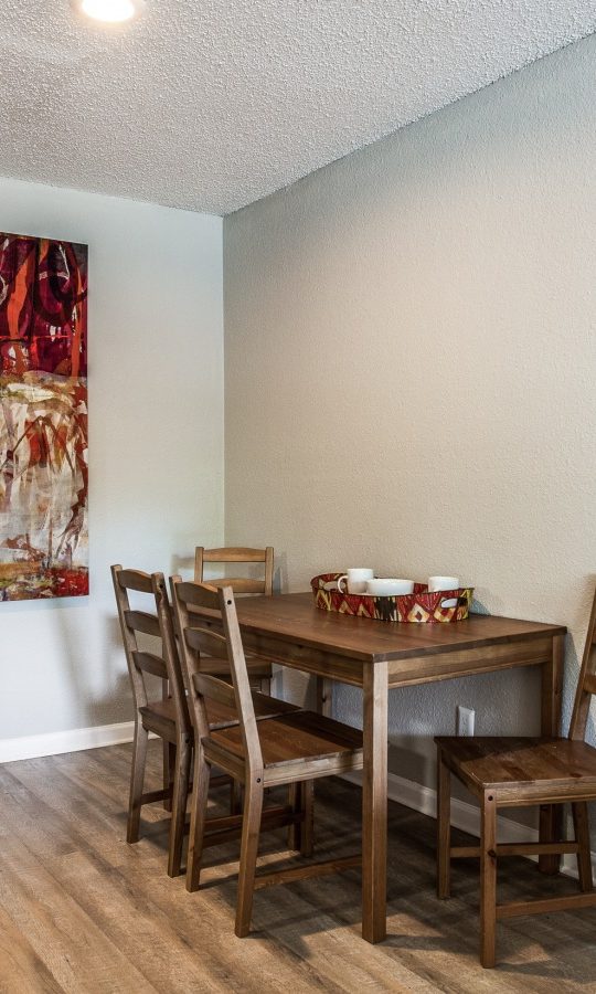 dining room with hardwood floors and a large painting at The Preslee